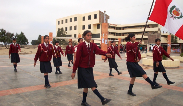 Alumnas con uniforme guindo desfilan en el aniversario de la Experimental UNS